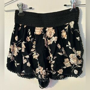 Super cute black shorts with peach and white roses
Size S